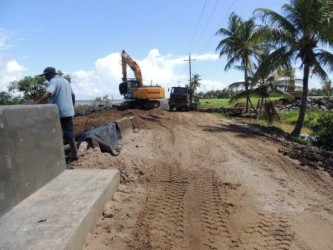 The sea defence work on Wakenaam. The road damage is evident in the background. (Ministry of Public Works photo)