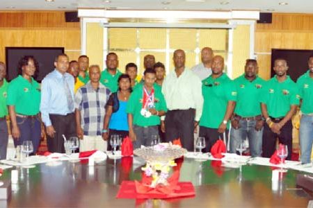 POWER MOVE! Guyana’s youngest ever World Champion, Gumendra Shewdas (with medals) poses with members of his family, executive members of the Guyana Amateur Power lifting, medalists at July’s Caribbean and Pan American Championships as well as Minister of Sport, Dr. Frank Anthony and Permanent Secretary of the Ministry during yesterday’s luncheon at the New Thriving Restaurant. (Orlando Charles photo)