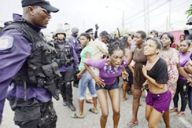 Protesters react to police officers at Beetham Gardens, Port of Spain on Monday. (Trinidad Express photo) 