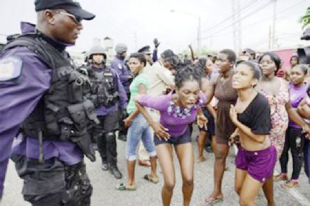 Protesters react to police officers at Beetham Gardens, Port of Spain on Monday. (Trinidad Express photo)
