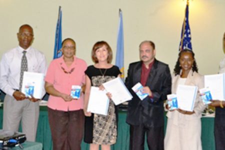 Minister of Health, Dr. Bheri Ramsaran (third from right) , representatives from PAHO, CDC and staff of the Ministry display the National Plan for Infection Prevention and Control 2012-2016 (GINA photo)