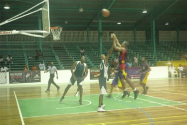 Albouystown/Charlestown top scorer Sheldon Thomas shoots over Lodge/Meadowbrook guard Pelham Doris on Saturday night at the Cliff Anderson Sports Hall. 