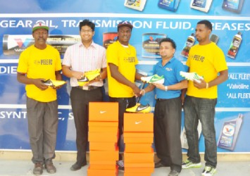 Pele Captain Shemroy Arthur (centre) receives the football cleats from Sankars Auto Works Manager Jones Raghubar (right) while team coach Barry Myers (extreme left), Marketing Manager Shiv Sankar (second left), and club member Marvin Goodman (extreme right) look on.