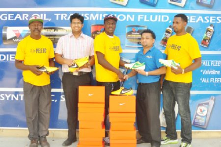 Pele Captain Shemroy Arthur (centre) receives the football cleats from Sankars Auto Works Manager Jones Raghubar (right) while team coach Barry Myers (extreme left), Marketing Manager Shiv Sankar (second left), and club member Marvin Goodman (extreme right) look on.