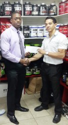  Mr. Guyana, Kerwin Clarke receiving his sponsorship cheque to cover his airfare to compete in the 41st annual Central American and Caribbean (CAC) Bodybuilding and Fitness Championships in the Dominican Republic from owner of Fitness Express, Jaime McDonald.