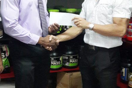  Mr. Guyana, Kerwin Clarke receiving his sponsorship cheque to cover his airfare to compete in the 41st annual Central American and Caribbean (CAC) Bodybuilding and Fitness Championships in the Dominican Republic from owner of Fitness Express, Jaime McDonald.