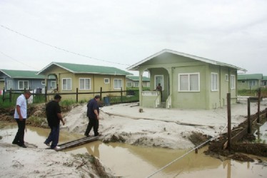 Minister of Housing and Water, Irfaan Ali (second from left) and Prime Minister of St. Vincent and the Grenadines, Ralph Gonsalves (third from left) visiting home owner, Radika Ramnauth.   (GINA photo)  