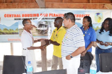 Timothy Daniels (left) receiving the keys to his new house from Permanent Secretary of the Ministry of Housing and Water, Emile McGarrel (GINA photo) 