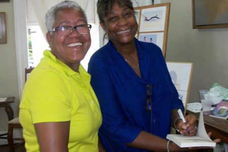  Maureen Marks-Mendonca (right) autographing a copy of her book for a fan.