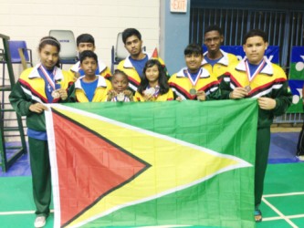 Members of the Guyana national badminton team which placed fourth at the just concluded Caribbean regional Badminton Confederation championships in Puerto Rico display the Guyana flag and their medals.