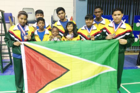 Members of the Guyana national badminton team which placed fourth at the just concluded Caribbean regional Badminton Confederation championships in Puerto Rico display the Guyana flag and their medals.