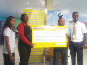 David Mohammed, Vice-President of the Lusignan Golf Club, receives the cheque for $250,000 from Courts Customer Experience Manager Shondell Bacchus yesterday afternoon in the presence of Kester Abrams, Courts Marketing Officer of Public Relations and Promotions and Joaan Deo. 