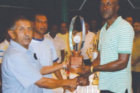 GFSCA organiser Wayne Jones (right) receiving tournament trophies from Ramchand Ragbeer.
