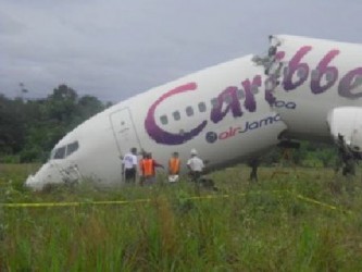 A US National Transportation Safety Board investigator along with local officials inspecting the Caribbean Airlines plane in August 2011 (Stabroek News file photo) 