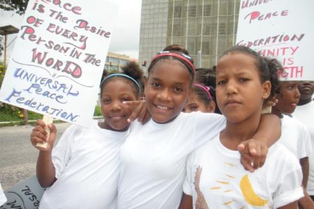 Three of the children who turned up for the Universal Peace Federation’s march for World Peace Day on Main Street yesterday. (Photo by Arian Browne)