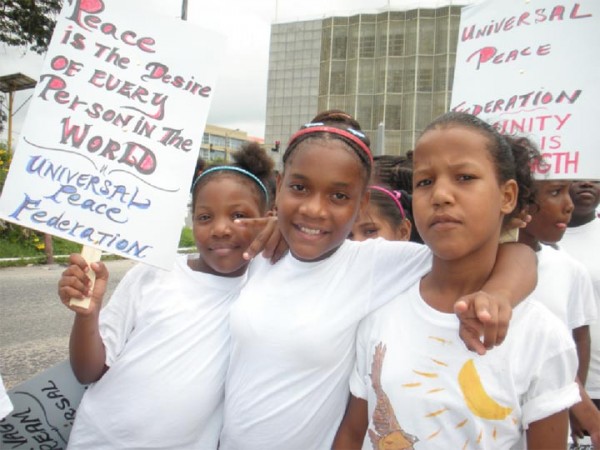 Three of the children who turned up for the Universal Peace Federation’s march for World Peace Day on Main Street yesterday. (Photo by Arian Browne)
