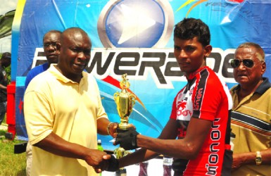 Winner! National Road Race champion, Raynauth Jeffrey receiving his trophy from Banks DIH’s Communications Officer Troy Peters after emphatically winning yesterday’s Powerade 50-mile road race. (Orlando Charles photo) 