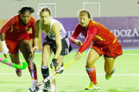 Argentina’s Carla Rebecchi (centre) battling Guyana’s Ulrica Sutherland (left) and Marzana Fiedtkou for possession of the ball during their team’s 22-0 defeat of Guyana on Tuesday at the PAHF Cup. (See story on page 26)