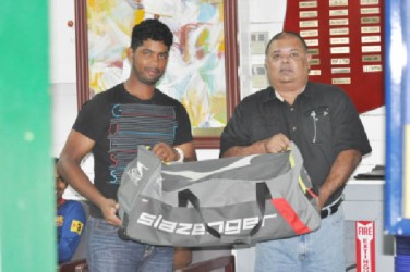 GCC president Lionel Jaikaran (right) hands over the cricket equipment to Robin Bacchus