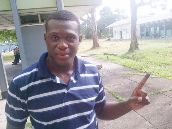 University of Guyana (UG) student Joshua David proudly displays his inked finger just seconds after voting in the UG Students Society elections at the Turkeyen Campus yesterday. (Photo by Chevy Devonish)