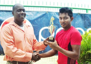 Man of the match Devendra Bishoo (right) receives his trophy from match referee Colin Stuart. (Orlando Charles photo) 