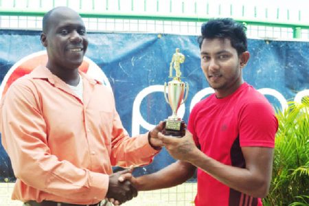 Man of the match Devendra Bishoo (right) receives his trophy from match referee Colin Stuart. (Orlando Charles photo)