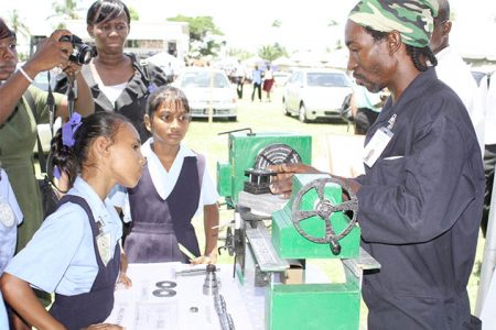 Primary school girls engrossed in the fitting and machining process being explained at the Guyana Industrial Training Centre booth at the Ministry of Education’s Technical Education and Vocational Training (TVET) career fair and exhibition yesterday at the ministry’s Sports Club Ground Carifesta Avenue. (Photo by Arian Browne)