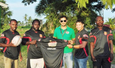 Stag Beer Manager, John Maikoo, presents the Stag practice jerseys to Theodore Henry (left) and Captain Ryan Gonsalves as Troy Bascom (extreme left) and Fitness Trainer Barrington Browne right watch on. (Orlando Charles photo) 