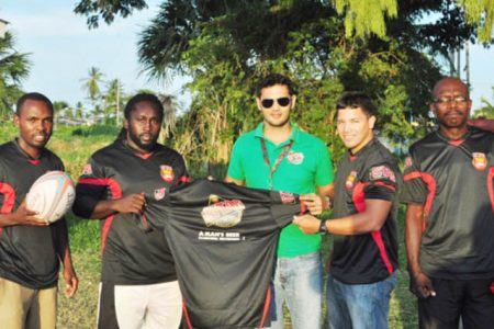 Stag Beer Manager, John Maikoo, presents the Stag practice jerseys to Theodore Henry (left) and Captain Ryan Gonsalves as Troy Bascom (extreme left) and Fitness Trainer Barrington Browne right watch on. (Orlando Charles photo)
