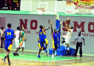 Albouystown/Charlestown’s Sheldon Thomas shooting over Werk-en-Rust/Wortmanville duo of Joslyn Crawford (number 12) and Michael Turner (number 8) in the first game of the best of three finals Friday night at the Cliff Anderson Sports Hall. 