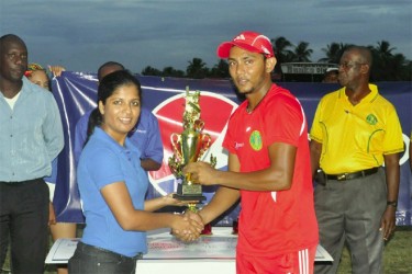   Devendra Bishoo receives the man of the match trophy. (Orlando Charles photo) 