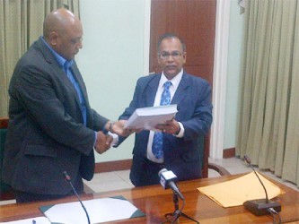 Auditor General Deodat Sharma (right) presents House Speaker Raphael Trotman with the 2012 Auditor’s Report 