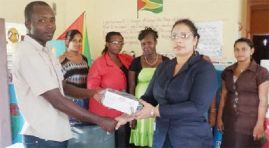 BBCI Administrative Assistant Bibi F Alli (second, right) handing over a television set, a DVD player and a voltage regulator to Sheet Anchor Nursery School. 