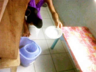 A parent bailing water out of the flooded classroom using a plate    