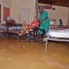 A nurse assists a resident of GH&DD’s Sanctuary—Home for the Elderly in Chuma Monka Avenue in Diego Martin yesterday morning as flood waters swamped the ground floor of the establishment. Several residents were transferred to higher ground on the compound.
