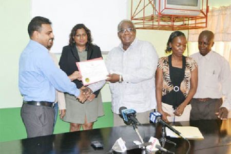 Chairman of the Board of Industrial Training, Clinton Williams (third from left) handing over the Apprenticeship licence to Barama’s Head of Corporate Affairs and Forest Planning,  Mohindra Chand. (GINA photo)
