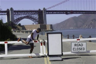A runner climbs over a road gate leading to Fort Point National Historic Site, which has been closed due to the federal government shutdown, in San Francisco, California October 2, 2013. REUTERS/Stephen Lam 