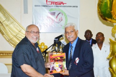 President Donald Ramotar (left) receives a copy of the Guyana Manufacturing and Services Association’s (GMSA) 50th Anniversary Souvenir Magazine from Publisher Lokesh Singh. (GINA photo)