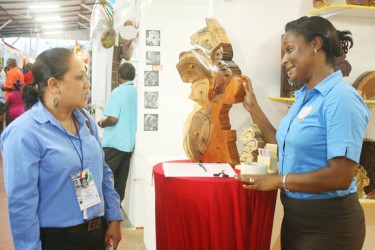 Jewellery box: Amanda Williams-Clarke (right) discusses her creative Map of Guyana jewellery box with  Nadia de Abreu at GuyExpo last night. 