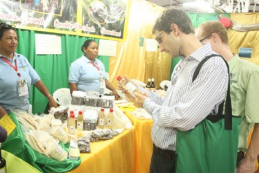 United Kingdom resident Andrew contemplating purchasing a bottle of extra virgin coconut oil from the Women’s Agro Processors Development Network