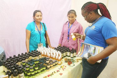 A patron reads the label on a product from ‘Medicine From Trees,’ an Annai-based producer 