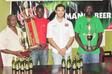  Brand Manager of Stag Beer, John Maikoo (centre) poses with the representatives of the BV/Triumph, Buxton United and the Mahaica Determinators following the distribution of cheques and trophies yesterday. (Orlando Charles photo) 