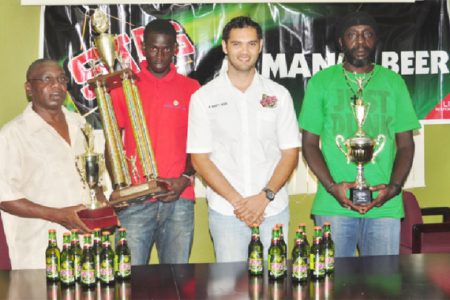  Brand Manager of Stag Beer, John Maikoo (centre) poses with the representatives of the BV/Triumph, Buxton United and the Mahaica Determinators following the distribution of cheques and trophies yesterday. (Orlando Charles photo)