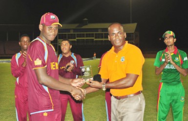 Man of the match Leroy Lugg receives his award from former West Indies leg spinner Rawl Lewis. (Orlando Charles photo)