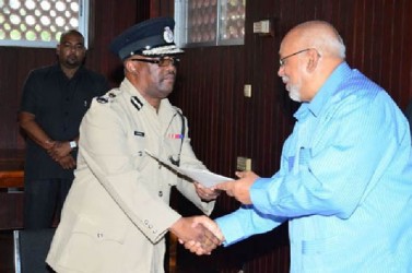 President Donald Ramotar handing over the certificate of appointment to newly confirmed Commissioner of Police Leroy Brumell (GINA photo)