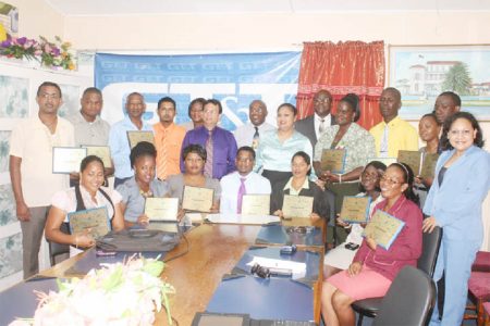 Honouring teachers: In observance of World Teachers Day, the Guyana Telephone and Telegraph Company yesterday honoured twenty  teachers, two from each region, with plaques, phone credit and Blackberry phones at discounted prices.  In photo, the twenty teachers pose with their plaques while Education Minister Priya Manickchand (standing seventh from right), Chief Education Officer (CEO) Olato Sam (standing sixth from right),  Guyana Teachers Union President Colin Bynoe (standing eight from right) and GT&T CEO Radha Krishna Sharma (standing ninth from right) watch on. 