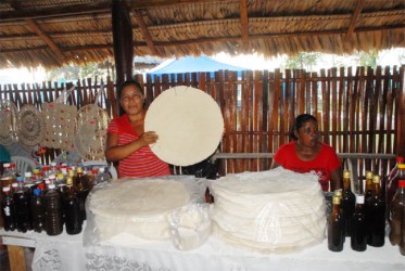 The women of Moraikabai show off a giant cassava bread and an assortment of Amerindian beverages at GuyExpo  XV