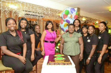 In photo: Nisa Walker (fourth from left) and some of her staff members pose with the anniversary cake  