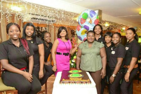 In photo: Nisa Walker (fourth from left) and some of her staff members pose with the anniversary cake 