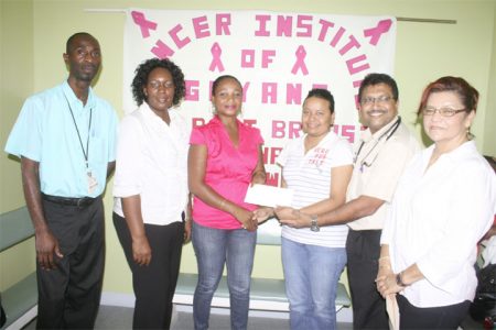Dr. Narendra Bhalla (second from right) receiving the cheque from a representative of the Avon Community Help Fund yesterday at the Cancer Institute of Guyana. (Photo by Arian Browne)